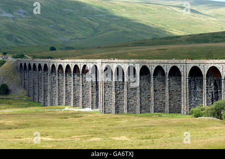 Some of the hundred's of people make the most of today's once in a life time opportunity to walk across the Ribblehead Viaduct on the Carlisle to Settle Rail-line in Cumbria. Stock Photo