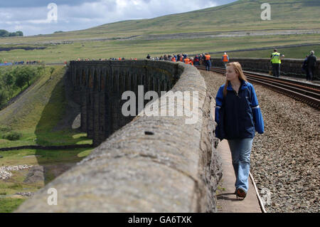 Lauren Barker along with hundred's of other people make the most of today's once in a life time opportunity to walk across the Ribblehead Viaduct on the Carlisle to Settle Rail-line in Cumbria. Stock Photo