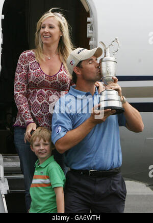 Ireland's Padraig Harrington kisses the Claret Jug alongside his wife Caroline and son Patrick at Weston Airport, Co. Kildare, Ireland. Stock Photo