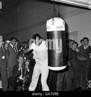 World heavyweight champion Muhammad Ali (Cassius Clay) hits a punch bag during his first work out since his arrival in London for his title defence against Henry Cooper. Stock Photo