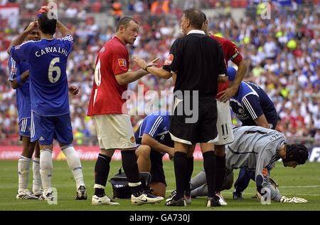 Manchester United's Wayne Rooney (left from centre) confronts referee Mark Halsey after his booking. Stock Photo