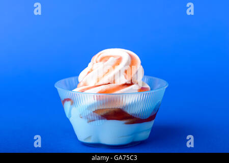 frozen yogurt with black cherry topping on blue background Stock Photo