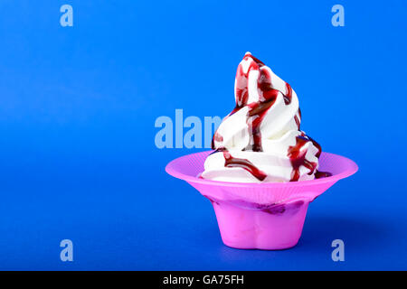 frozen yogurt with black cherry topping on blue background Stock Photo