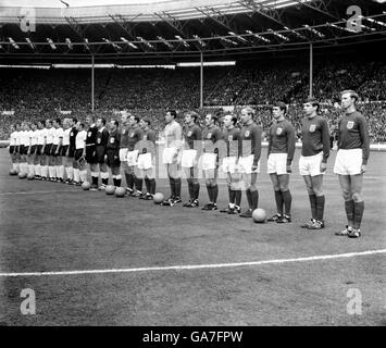 The two teams line up before the match: (l-r) West Germany's Horst-Dieter Hottges, Wolfgang Overath, Siggi Held, Helmut Haller, Wolfgang Weber, Lothar Emmerich, Willi Schulz, Franz Beckenbauer, Karl-Heinz Schnellinger, Hans Tilkowski and Uwe Seeler, linesman Tofik Bakhramov, referee Gottfried Dienst, linesman Karol Galba, England's Bobby Moore, George Cohen, Alan Ball, Gordon Banks, Roger Hunt, Ray Wilson, Nobby Stiles, Bobby Charlton, Geoff Hurst, Martin Peters, Jack Charlton Stock Photo