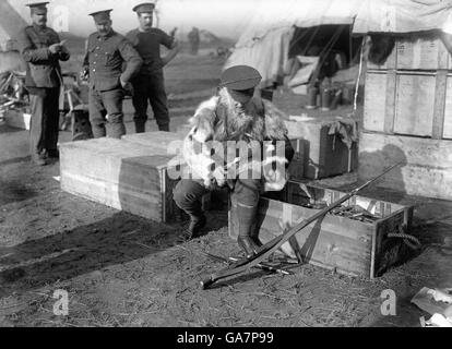 A British soldier, wearing an improvised fur jacket to protect him from the cold, checks through his equipment in a transit camp behind the front lines in France. Stock Photo