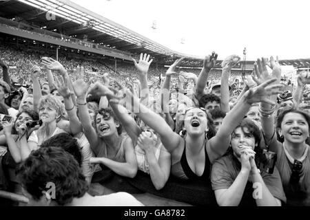 Adoring Wham fans pay homage to their heroes, George Michael and Andrew Ridgeley when the stars bounded onto the Wembley Stadium stage for their sell-out farewell concert. Some 75,000 were said to be there to see the duo's final appearance together after four years. Stock Photo