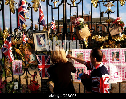 Mourners place flowers at the gates outside Kensington Palace - the former home of Diana, Princess of Wales - ahead of today's Service of Thanksgiving. Stock Photo