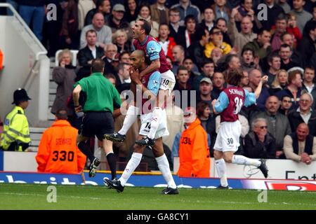 West Ham United's Paolo Di Canio (top) jumps on the back of scorer Frederic Kanoute after his goal against Manchester United Stock Photo