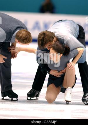 Canada's Jamie Sale is helped up from the ice by partner David Pelletier (l) and Russia's Anton Sikharulidze (r) after he accidentally crashed into her in the practice warm up Stock Photo