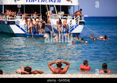 Tourists enjoy a summer evening at Xigia beach as a boat with other tourists approaches in Zakynthos on July 25, 2015. Stock Photo