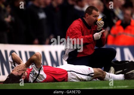 Soccer - AXA FA Cup - Quarter Final - Replay - Arsenal v Newcastle United. Arsenal's Robert Pires lies in agony as the Arsenal physio gets on radio to get a stretcher on for the injured player Stock Photo
