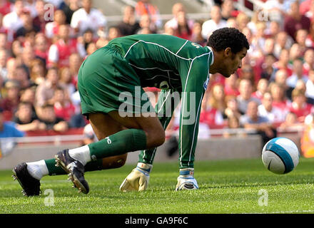 Portsmouth goalkeeper David James stops a shot during the Barclays Premier League match at the Emirates Stadium, London. Stock Photo