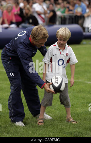 Rugby Union - England O2 Scrum In The Park - Regents Park. England's Jonny Wilkinson teaches a young player how to kick during the O2 Scrum In The Park day in Regents Park, London. Stock Photo