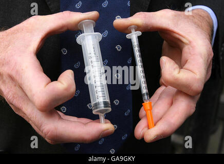 A doctor shows the difference between a Ten Unit and a Thousand Unit Syringe outside Belfast Coroner's Court, following the inquest into the death of 92-year-old Walter Kenneth Johnston. Mr Johnston suffered a heart attack and died after a junior doctor injected him with 100 times the correct dose of insulin. Stock Photo