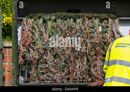 Yellow vest hi-vis BT repair engineer, on-street cabinets, street, cables, working on a tangkled maze of fibre broadband wires at Southport, Merseyside, UK August, 2016. Ofcom has today announced progress on measures to make digital communications, ADSL broadband kit & work for everyone – including major reform of Openreach.  Campaign group says Open reach is in need of 'radical change' as further improvements to the service are rolled out. Stock Photo