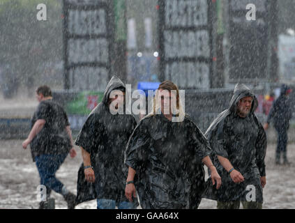 Wacken, Germany. 5th Aug, 2016. Heavy metal fans walking through pouring rain at the Wacken Open Air festival in Wacken, Germany, 5 August 2016. 75,000 fans are attending what organisers say is the largest heavy metal festival in the world. PHOTO: AXEL HEIMKEN/DPA/Alamy Live News Stock Photo