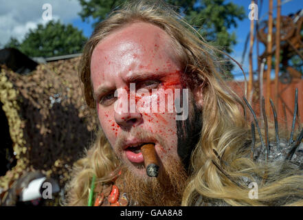Wacken, Germany. 5th Aug, 2016. A Metal fan with fake blood and a cigar on the festival grounds of Wacken Open Air in Wacken, Germany, 5 August 2016. 75,000 fans are attending what organisers say is the largest heavy metal festival in the world. PHOTO: AXEL HEIMKEN/dpa/Alamy Live News Stock Photo