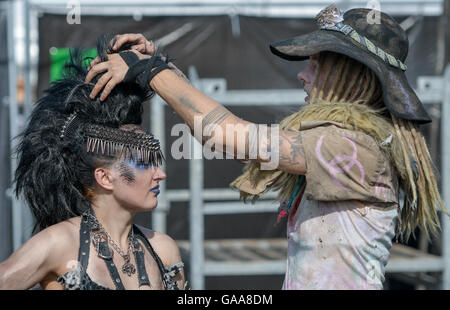 Wacken, Germany. 5th Aug, 2016. A woman helping another woman fixing her hair on the festival grounds of Wacken Open Air in Wacken, Germany, 5 August 2016. 75,000 fans are attending what organisers say is the largest heavy metal festival in the world. PHOTO: AXEL HEIMKEN/dpa/Alamy Live News Stock Photo