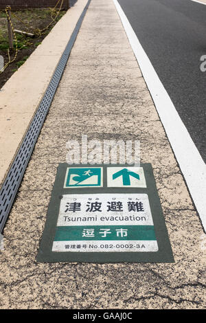 A sign on the road indicates a tsunami evacuation route in Zushi city, Japan Stock Photo