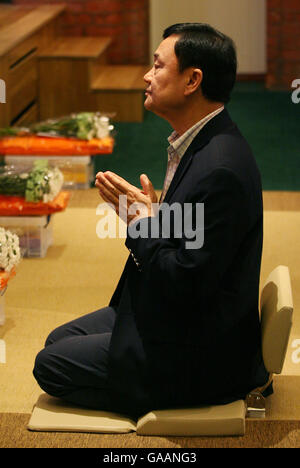 Dr. Thaksin Shinawatra, former Prime Minister of Thailand, during prayers at the Dhammakaya Centre for Buddist Meditation in Knaphill, Surrey, a year after being ousted from office. Stock Photo