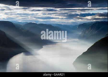 Lysefjorden viewed from the Preikestolen (Pulpit rock) on misty summer morning with sun rays shining down, Forsand, Rogaland, Norway. Stock Photo