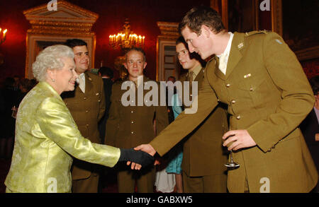 Queen Elizabeth II meets soldiers serving with the Queen's Royal Lancers during a reception, at St James's , London marking the Sixtieth Anniversary of her Colonelcy in Chief. The men, who are based at Catterick, North Yorkshire, are from left to right , Captain Nick Wildbur, Trooper Josh Libro, Trooper Timmy Taylor and, shaking hands, Lt William Pope. Stock Photo