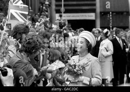 Two young men have the Queen rocking with laughter at St Katherine's Dock, where she met the people during one of the stops on her Silver Jubilee river progress from Greenwich to Lambeth in the Port of London Authority launch Nore. Stock Photo