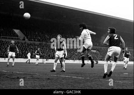 West Ham United's Bobby Moore (l), Tommy Taylor (c) and John McDowell (r) look on as Manchester United's George Best (second r) heads for goal Stock Photo