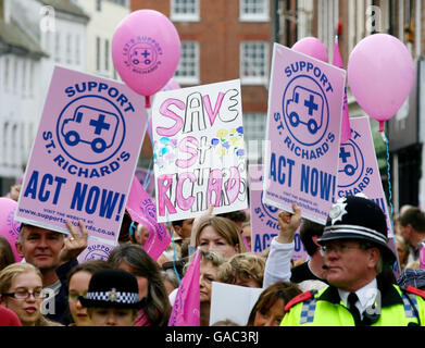 Demonstrators hold placards during a rally in Priory Park Chichester, Sussex against proposed cuts in services at St. Richard's Hospital. Stock Photo