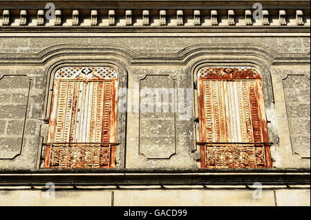 Large white weathered and rusty closed window metal shutters Stock Photo
