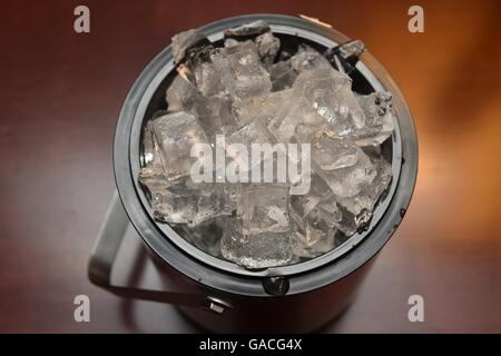 Ice cubes in a cooler bucket and tongs next to it Stock Photo