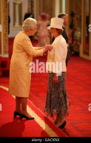 Mrs. Catherine Robertson, teacher, Bankhead Primary School, Glasgow, from Glasgow, receives an MBE from The Queen at Buckingham Palace, for services to Education. Stock Photo