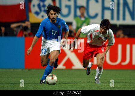(L-R) Italy's Damiano Tommasi and Republic Of Korea's Chul Sang Yoo battle for the ball Stock Photo