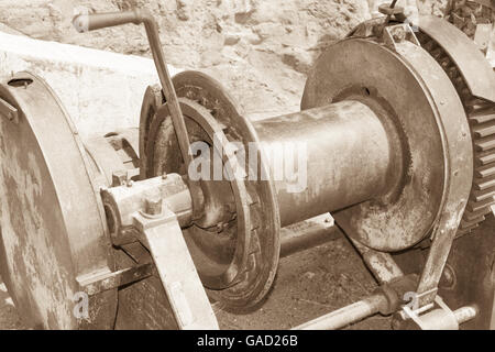 Antique Winch used to hoist supplies up side of mountain. Emergency handle used to manually operate when electric motor failed. Stock Photo