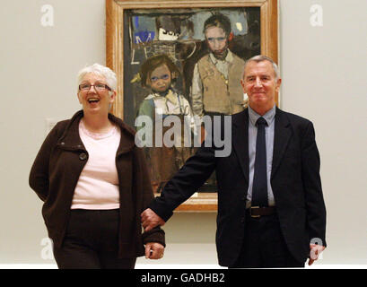 (Left to right) Mary McDonald and Andrew Samson, the children painted by Joan Eardley in the painting behind. It's part of the Joan Eardley exhibition at the National Gallery of Scotland, Edinburgh. Stock Photo