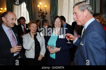 The Prince of Wales (right) talks with (from left), Roderick MacKinnon from Bexley Grammar School, Brenda Wallace from Gumley House Convent School, Middlessex and Anne Shinwell from Parkstone Grammar School, Dorset, at a reception which the Prince hosted at Clarence House, central London for head teachers from schools which sent delegates to The Prince's Teaching Institute Summer Schools. Stock Photo