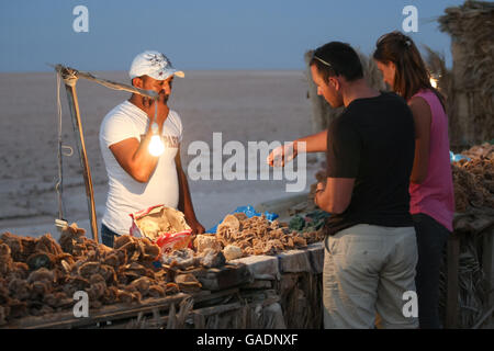 Tourists buying desert rose souvenir at Chott El Jerid, a large salt lake in southern Tunisia. Stock Photo