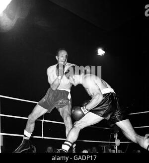 European Heavyweight Champion Jose Urtain (r) ducks as challenger Henry Cooper (l), bleeding from a cut above his eye, throws a left jab Stock Photo