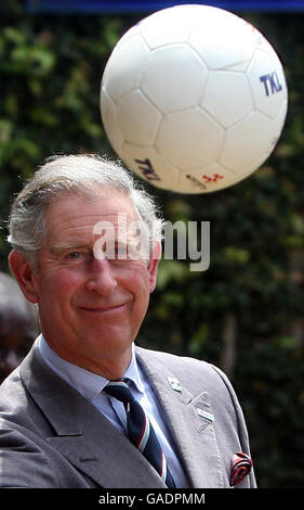 Prince Charles passes a football to a Ugandan children playing football at the Kampala Kids League football training centre in Uganda, where the Commonwealth Heads of Government Meeting (CHOGM) is taking place in the capital, Kampala. Stock Photo