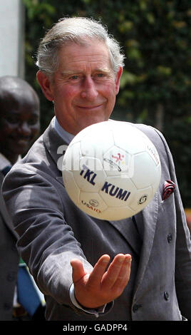 Prince Charles passes a football to Ugandan children at the Kampala Kids League football training centre in Uganda. The Commonwealth Heads of Government Meeting (CHOGM) is taking place in the capital, Kampala. Stock Photo