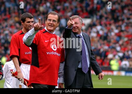 Roger Moore (former James Bond) and Manchester United Manager Sir Alex Ferguson with Roy Keane in the background Stock Photo