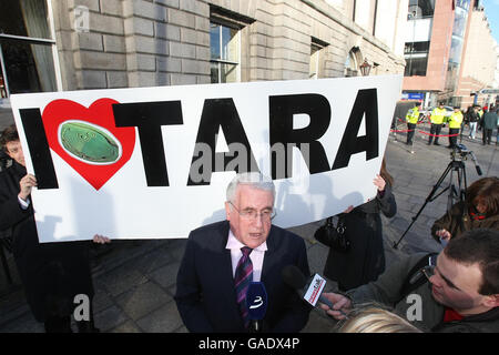 Europe Minister Dck Roche TD is interviewed by reporters with a Save Tara campaign banner held by Vincent Salafia (left) behind him. Stock Photo
