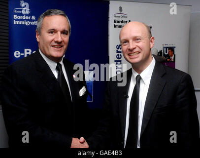 Chief Executive Officer of Raytheon Company Bill Swanson (left) and Immigration Officer Liam Burne MP (right) shake hands after Raytheon Company were unveiled as the winning providers of technology to the new eBorders system at the Home Office in Westminister, central London. Stock Photo