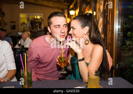 Young beautiful couple with cocktails in bar or club Stock Photo