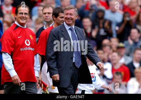 Manchester United's Manager Alex Ferguson (r) leads his team out with UNICEF Goodwill Ambassador Roger Moore CBE (l) Stock Photo
