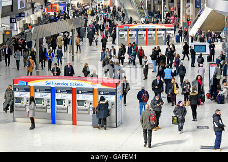 Looking down on passengers & commuters two sets Self Service ticket machines at busy Waterloo train station in Lambeth London England UK Stock Photo