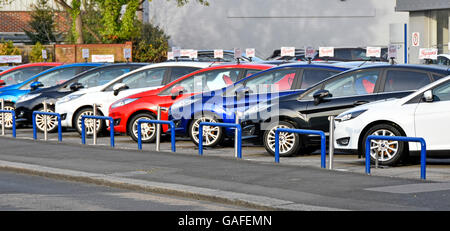 Car dealer display of used cars for sale on main Ford dealership pavement forecourt outside car showroom Brentwood Essex England UK