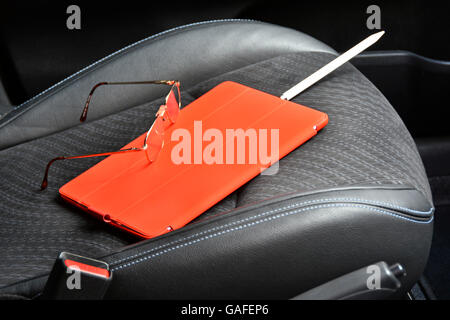 Apple pencil charging in iPad Pro 9.7 inch tablet in cover on car seat valuable property & belongings left on display inside car Stock Photo