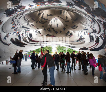 Tourists taking photos under the Cloud Gate sculpture in Millennium Park, Chicago, Illinois. Stock Photo