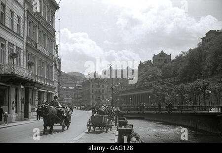 1930s, historical view of Karlsbad or Karlovy Vary, in the Sudetenland, in pre-WW11 Czechoslovakia. The grand Hotel Goldener Lowe is on the left, the Mill Colonnade on the right. Stock Photo